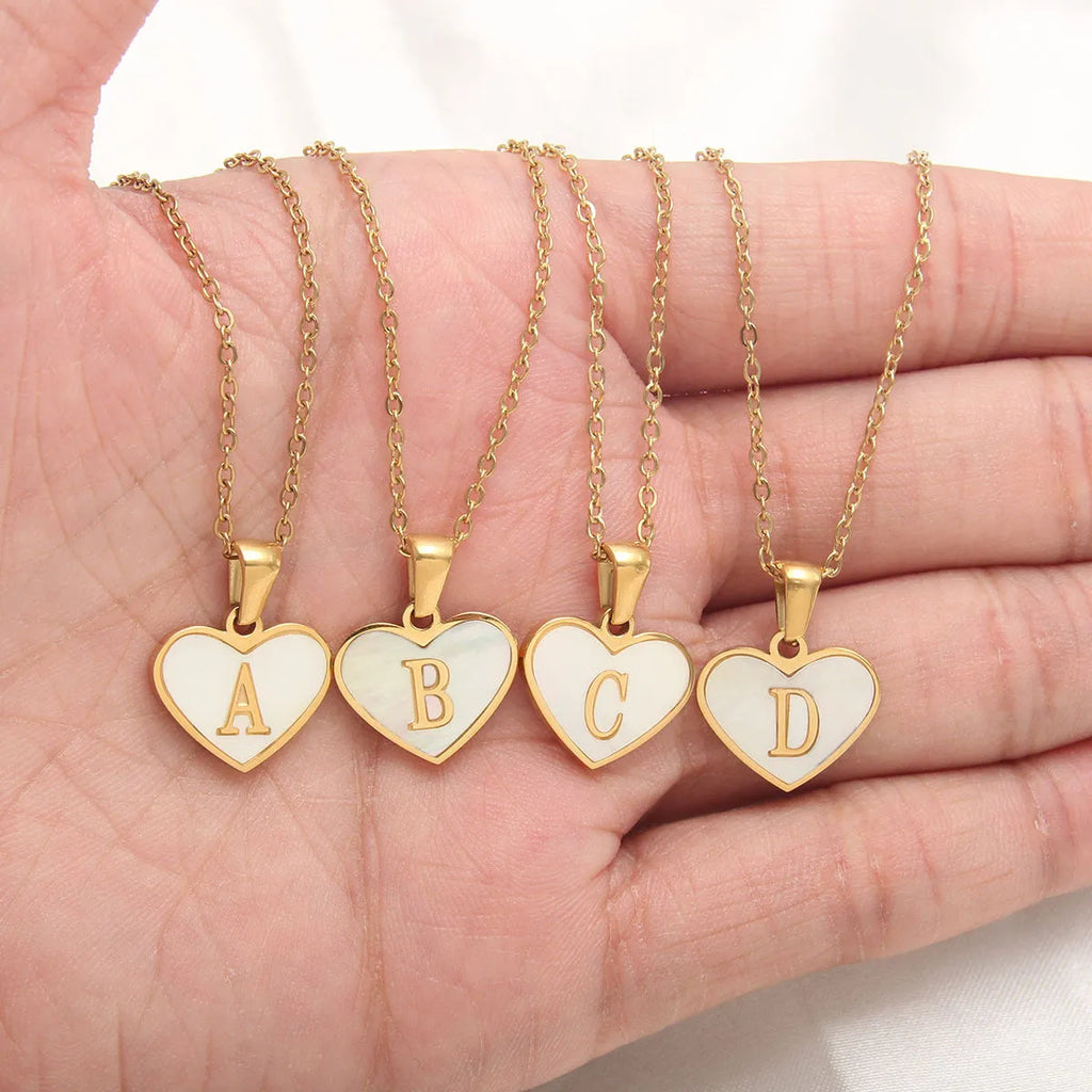 Gold-plated heart-shaped white shell pendant necklace on a stainless steel chain with extendable clasp