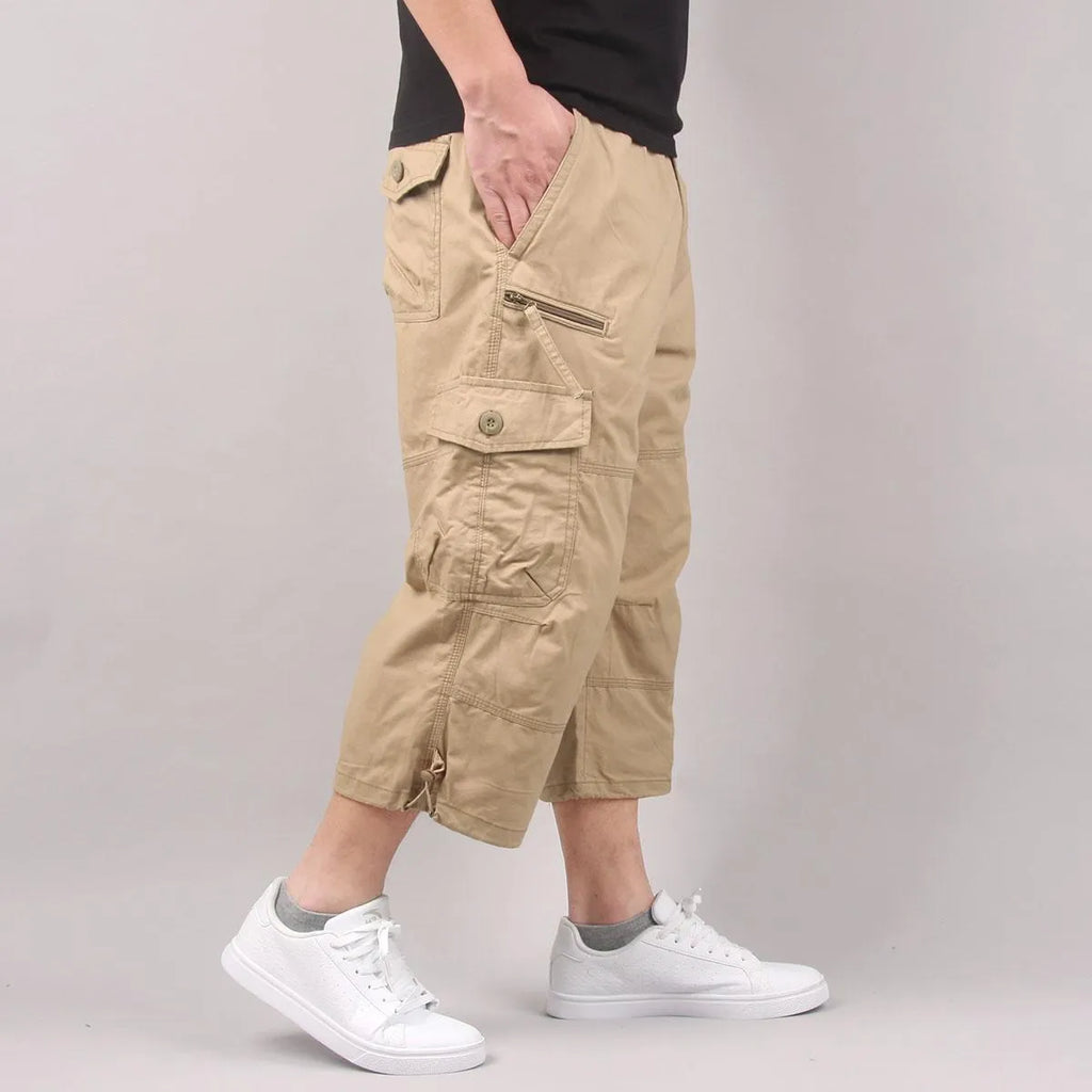 Man wearing loose, cropped cotton casual pants in army green, suitable for sports.
