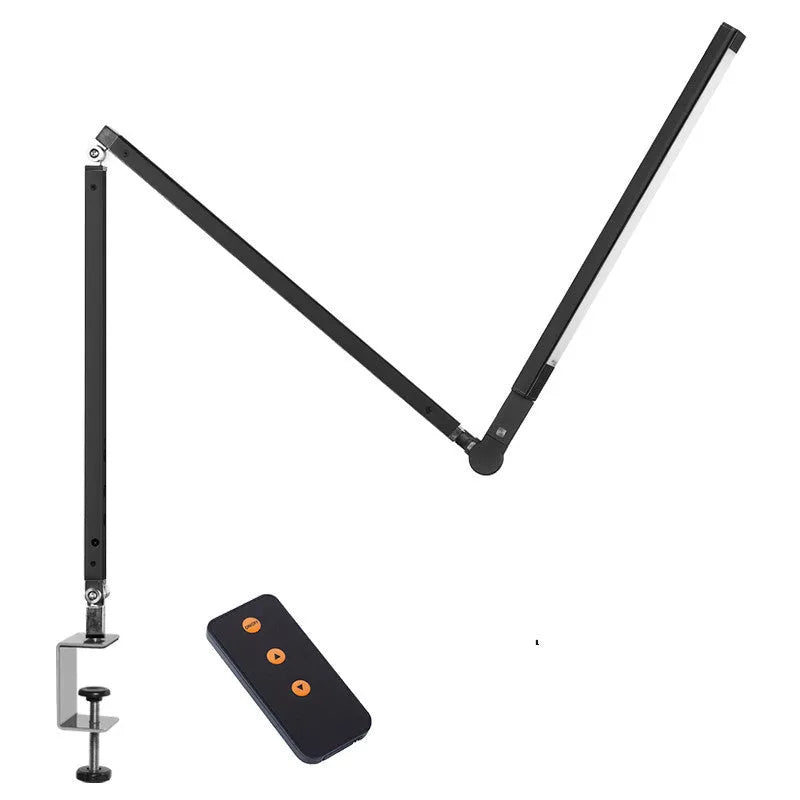 Black folding clip-on LED desk lamp with remote control on a wooden desk.