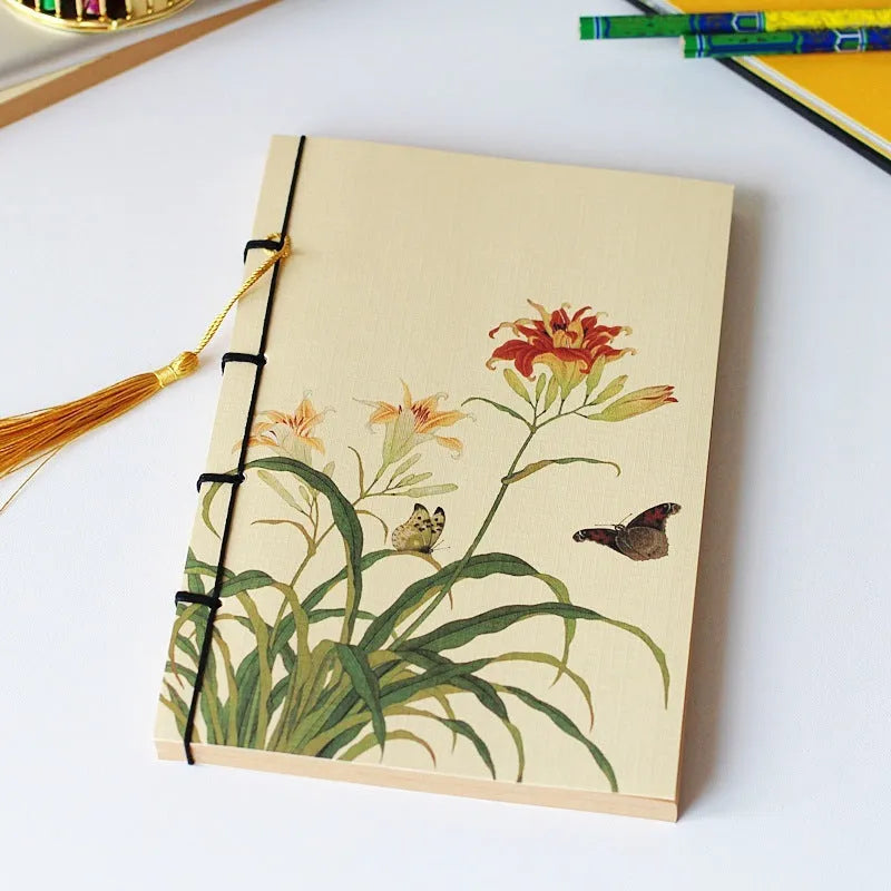 A5 antique wire-bound notebook with glossy embossed cover featuring a retro painting design, shown open.