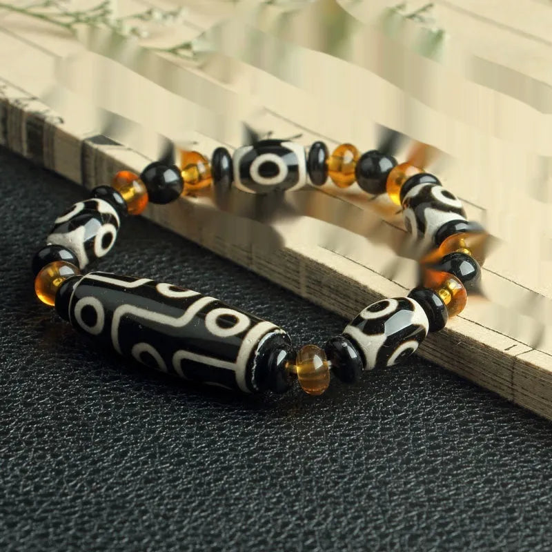 Distressed agate bracelet with traditional Tibetan dzi beads including three-eye and Nine Eyes designs.