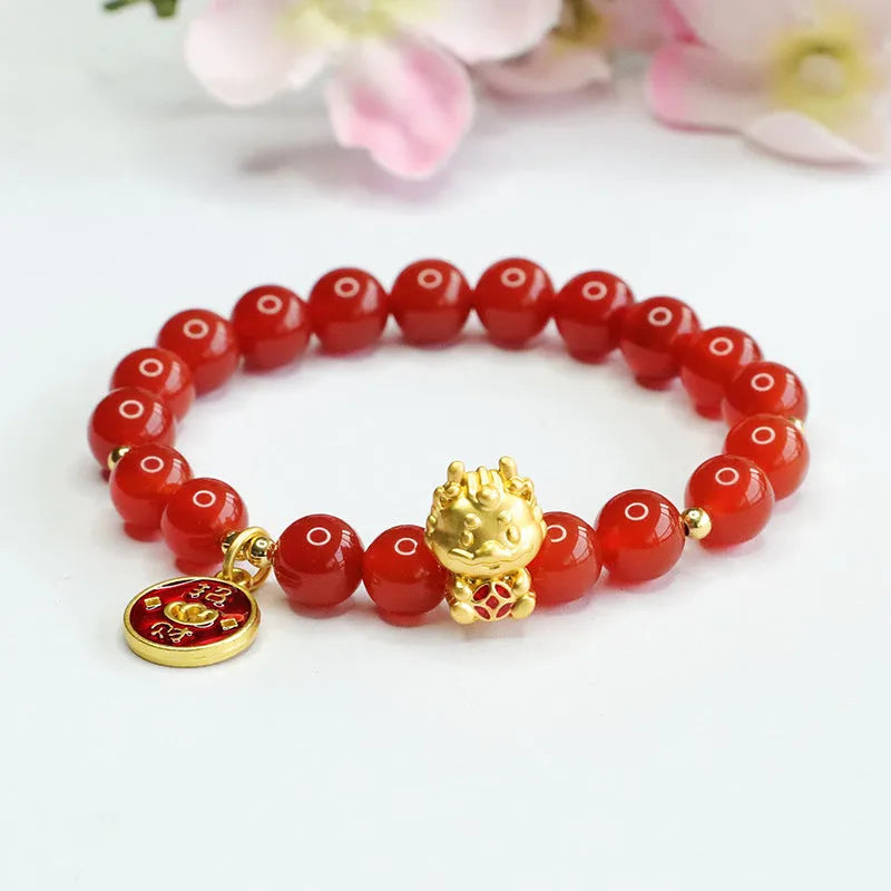 Close-up of a red agate beaded bracelet with a dragon zodiac charm on a wrist.