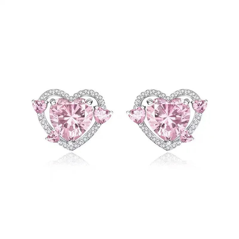 White gold colour heart-shaped stud earrings for women on a jewellery card.