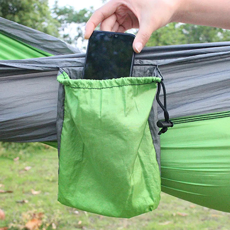 Blue nylon parachute cloth camping hammock hung between two trees.