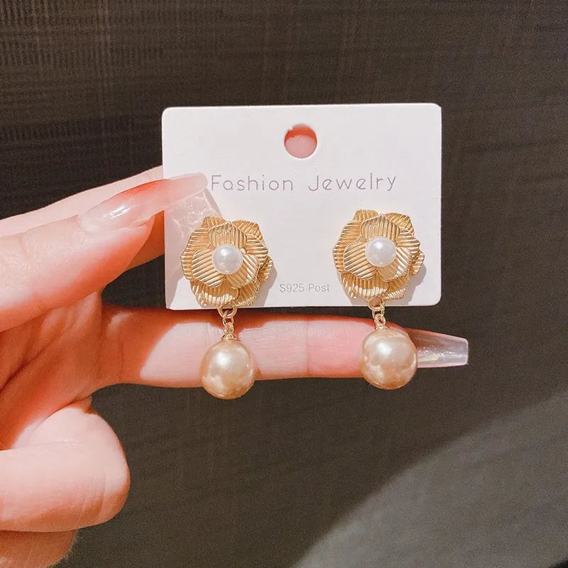 Gold floral stud earrings with rose pearl design, ice flower details, and a central opal stone.