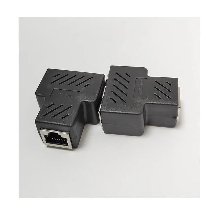 Two white RJ45 three-way network tee splitters on a table.