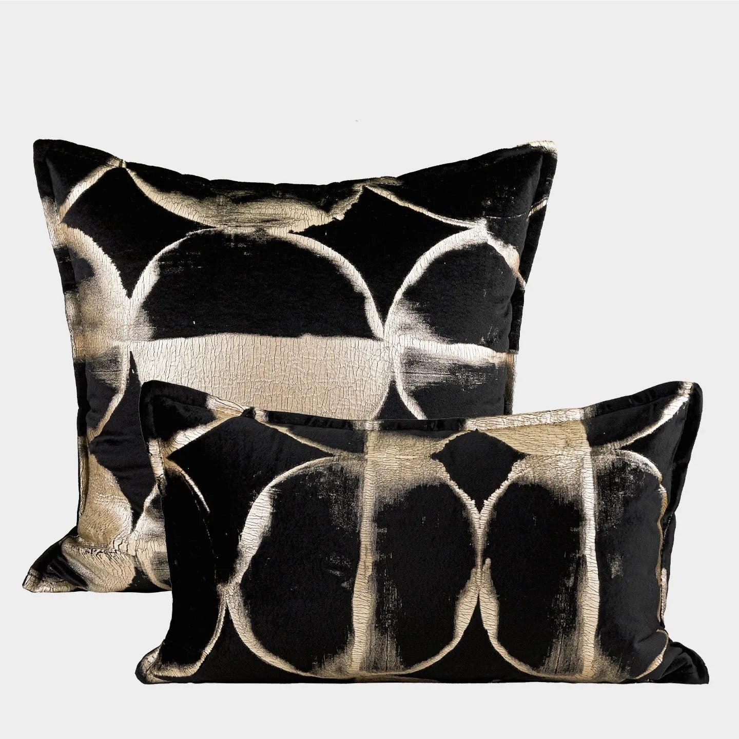 Black and gold abstract pattern decorative flannel pillow with removable cover on a grey sofa.