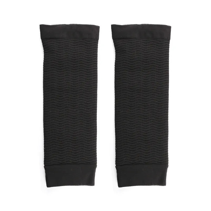 A pair of solid-colour women's shaping arm sleeves in nylon, shown in black and skin tone on a mannequin arm.