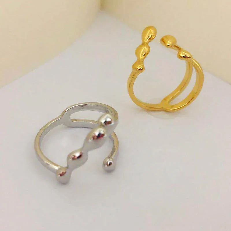 Women's brass open ring with spherical elements in gold finish showing adjustable band design