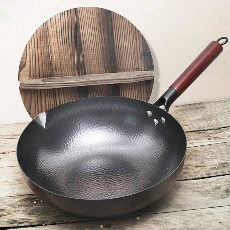 Traditional black iron wok with wooden handle measuring 32cm in diameter