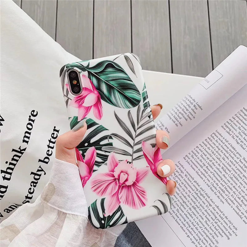 Pink floral pattern TPU back cover case for iPhone on a table.