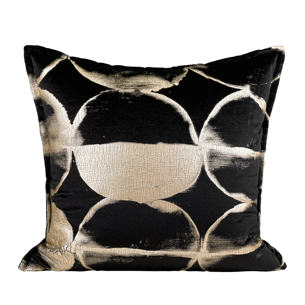 Black and gold abstract pattern decorative flannel pillow with removable cover on a grey sofa.