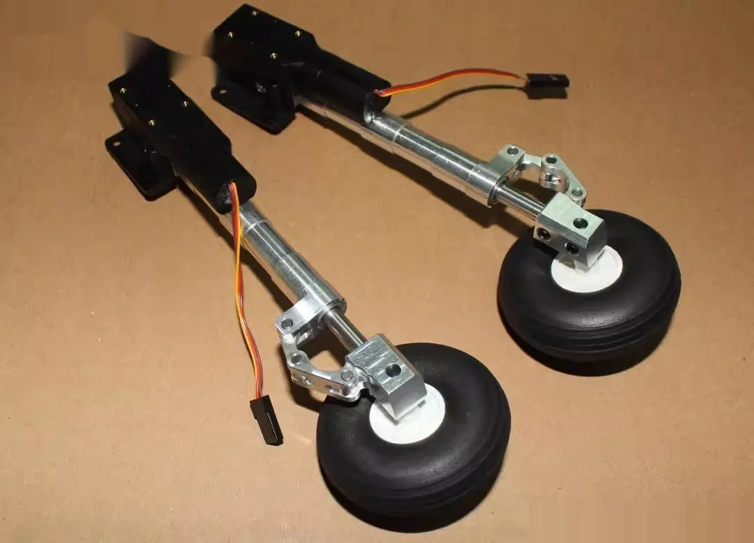 Retractable alloy landing gear with wheels for toy aircraft, shown in inclined kneeling shock-absorbing position.