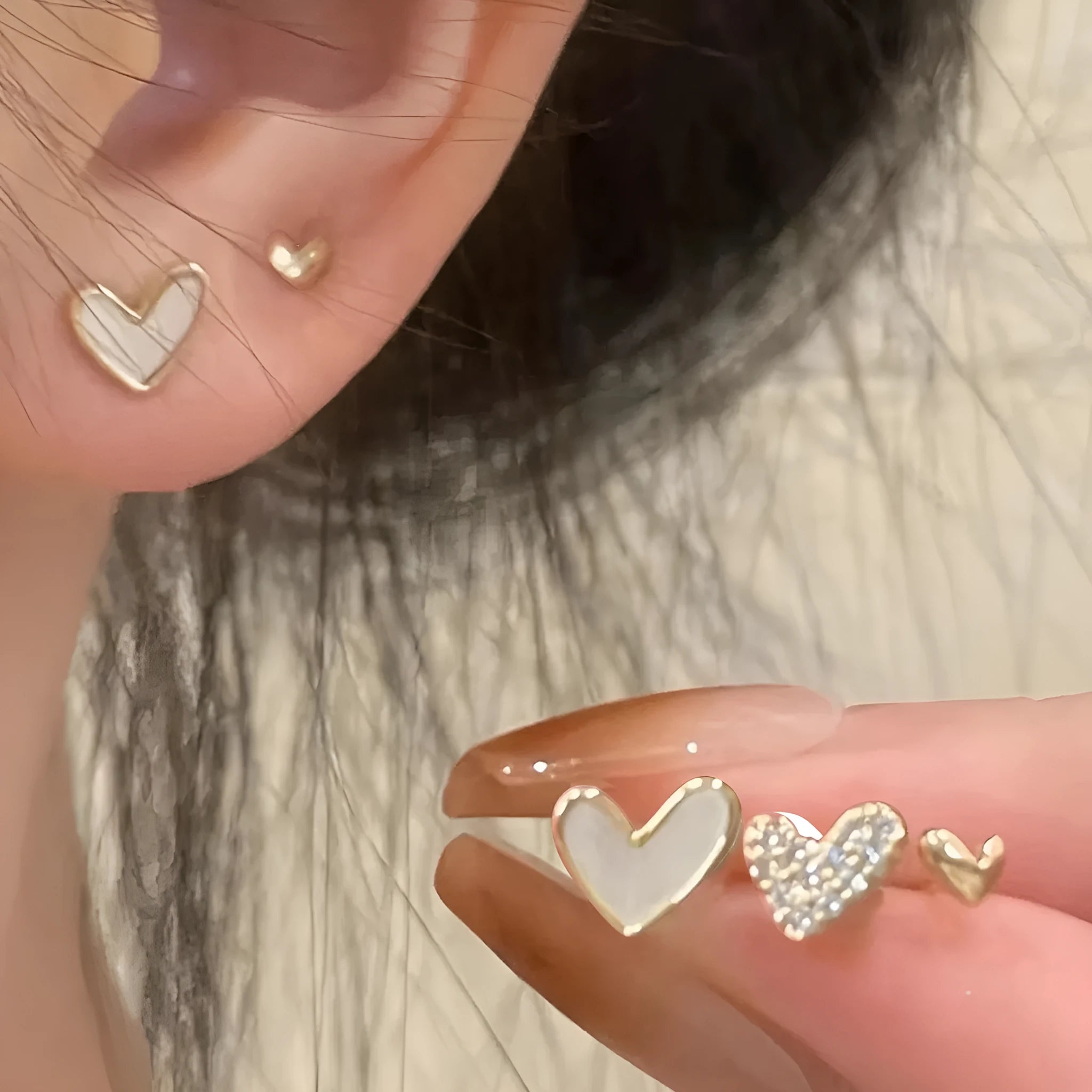 Three pairs of women's heart-shaped alloy earrings in gold, black, pink and black-white colours