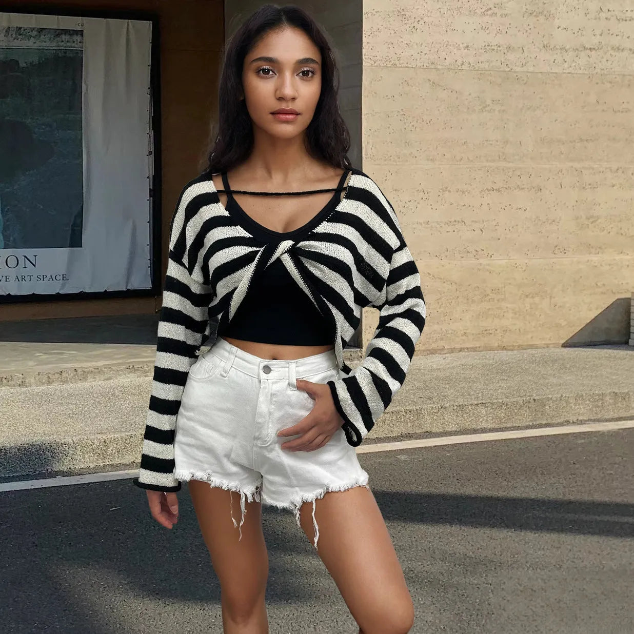 Women's black and white striped long-sleeved sweater with an exposed navel design, worn as a front and back wearable top.