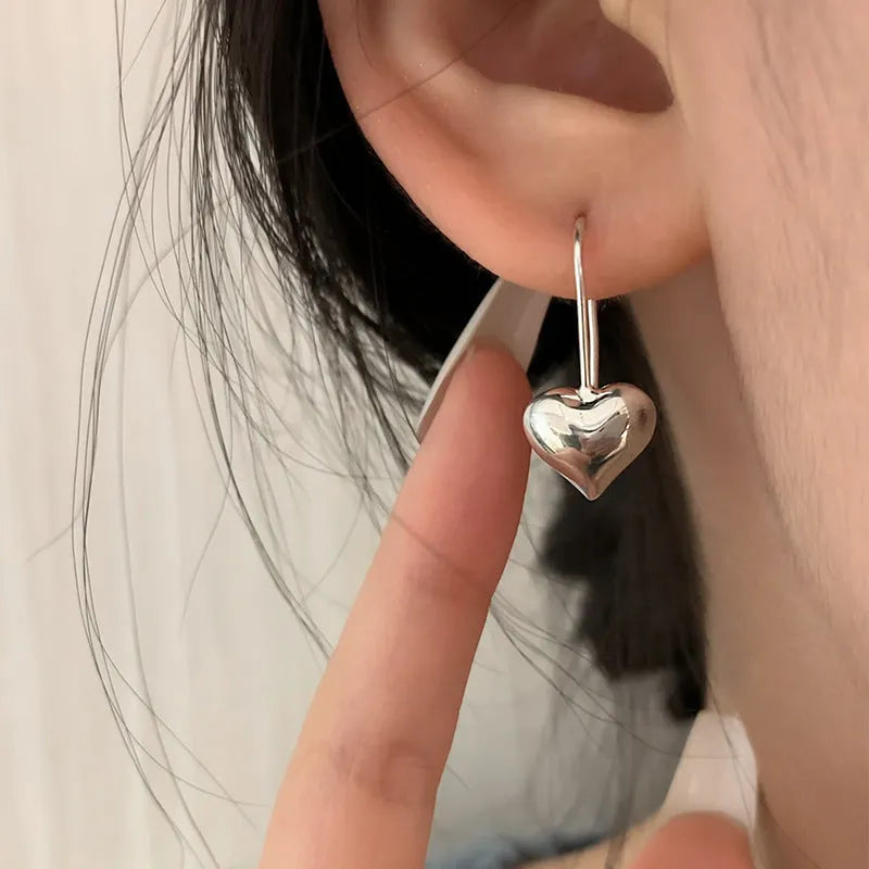 Silver heart-shaped copper earrings with three-dimensional glossy finish and Korean-style design