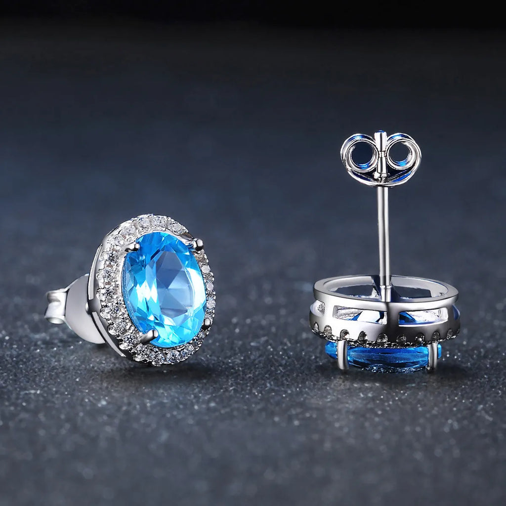 925 sterling silver geometric jewellery set with blue topaz gemstones, showing earrings, ring, pendant, and necklace.
