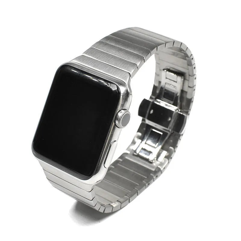 Silver stainless steel Apple Watch strap with butterfly buckle on a wrist.