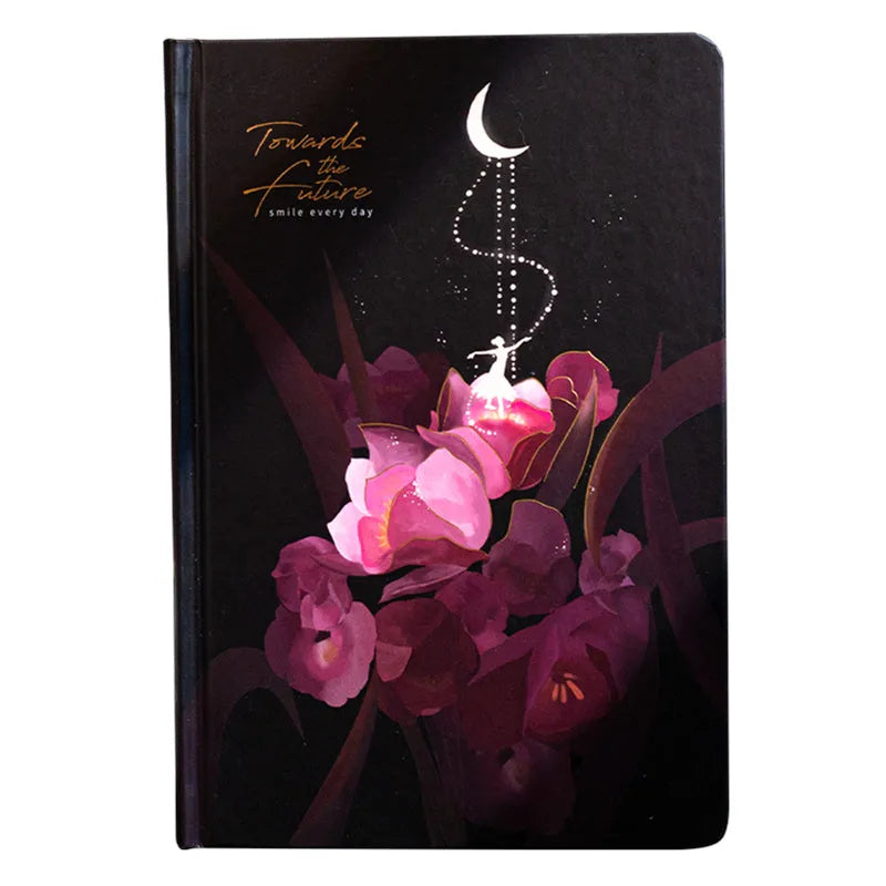 A5 notebook with luminous holographic cover lying flat, showing colourful illustrated interior pages.