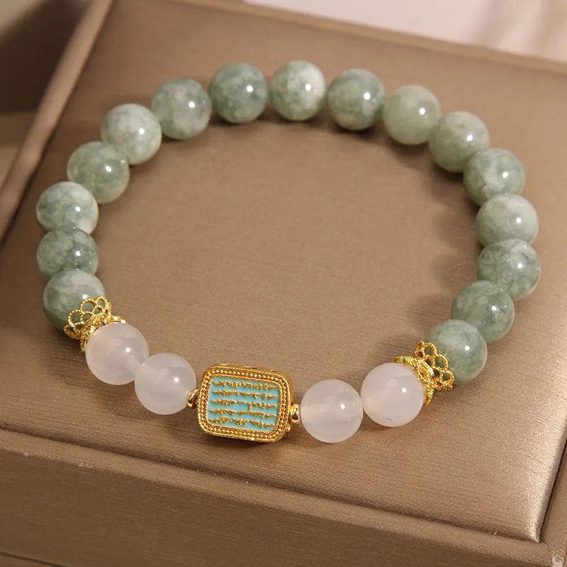 Women's oil green emerald crystal bracelet with five scriptures design on a wrist.