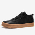 Men's black leather casual shoes with round toe, flat heel, and white rubber sole on a plain background.