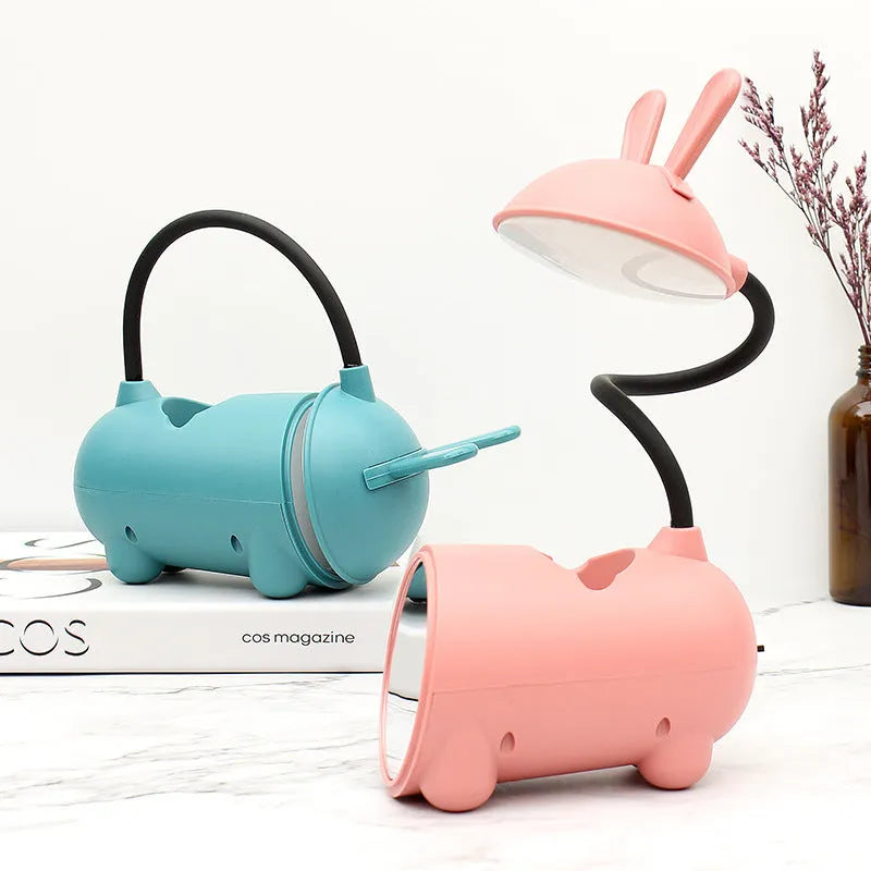 Cartoon-style USB desk lamp with pen storage compartment in green, blue, or pink colour options