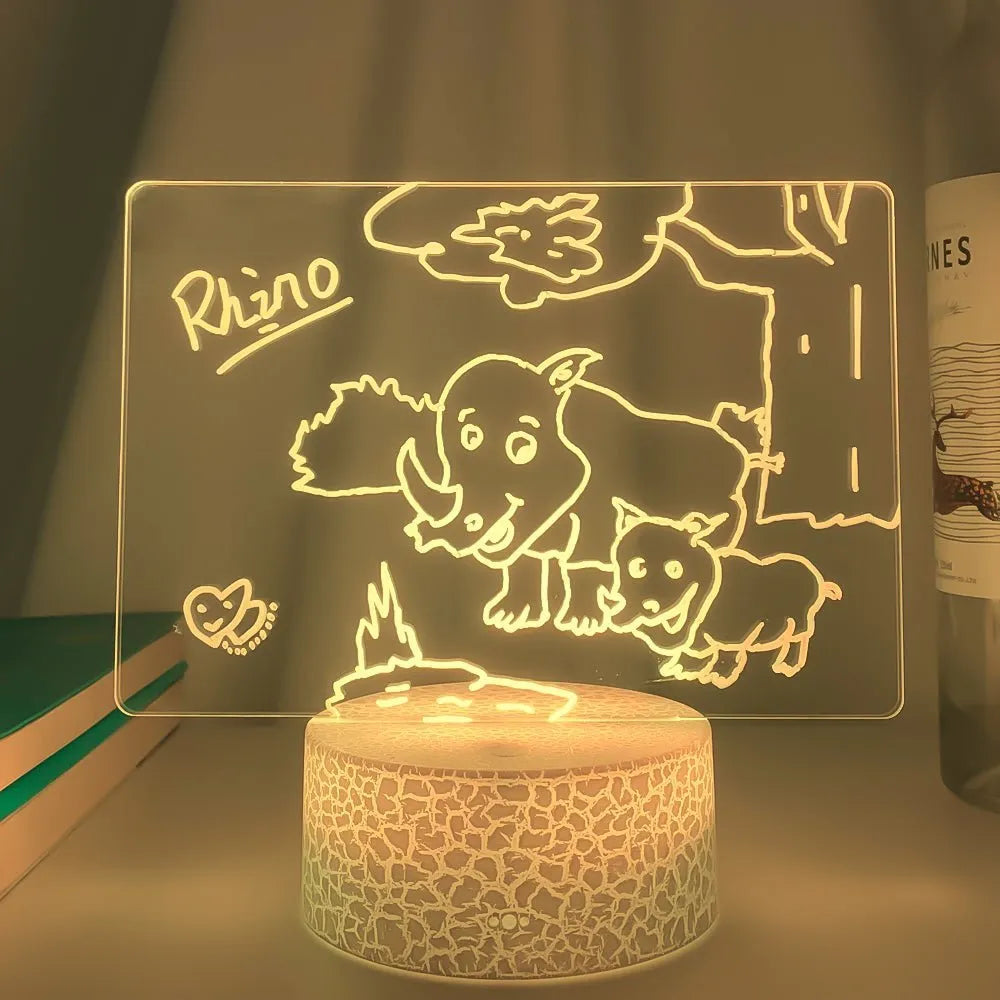 3D acrylic message board night light with remote control on a desk, showing 16 colour options.