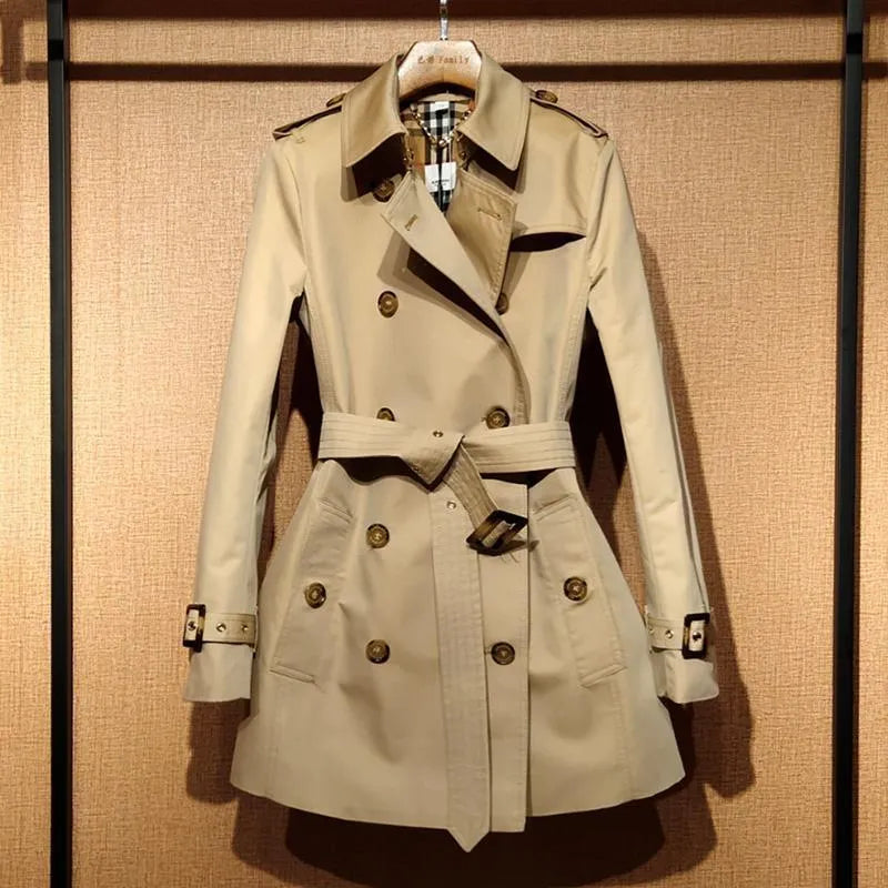 Khaki women's double-breasted trench coat with flight sleeves on a hanger.