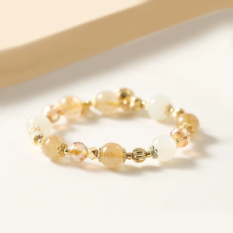 Gold electroplated adjustable bracelet with lucky fortune rutilated quartz crystal beads in a Korean style.