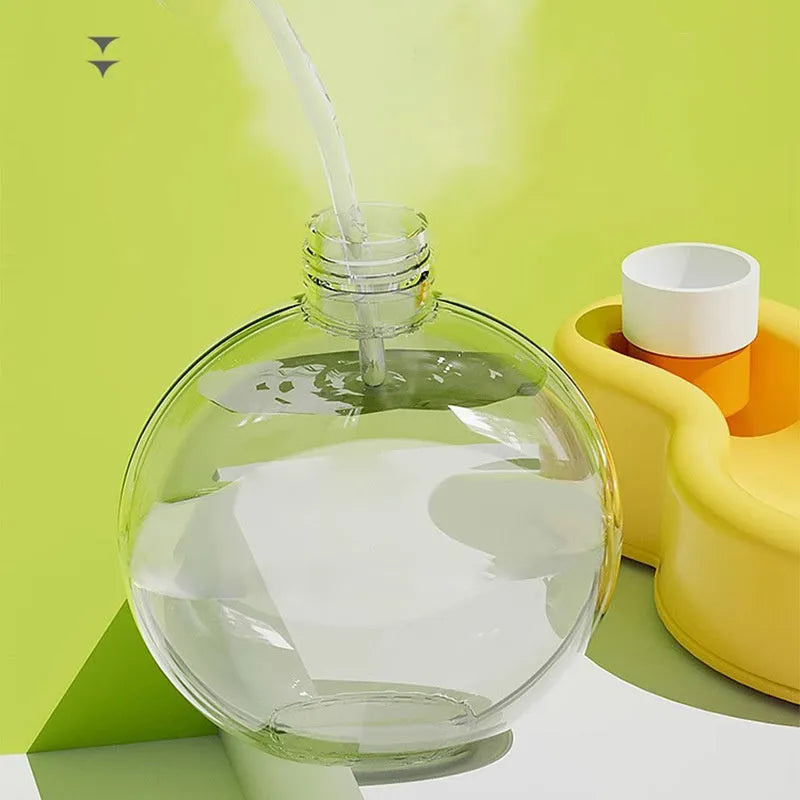 Green portable dog travel cup with pull-out drinking bowl and handle, shown with orange and yellow colour options.