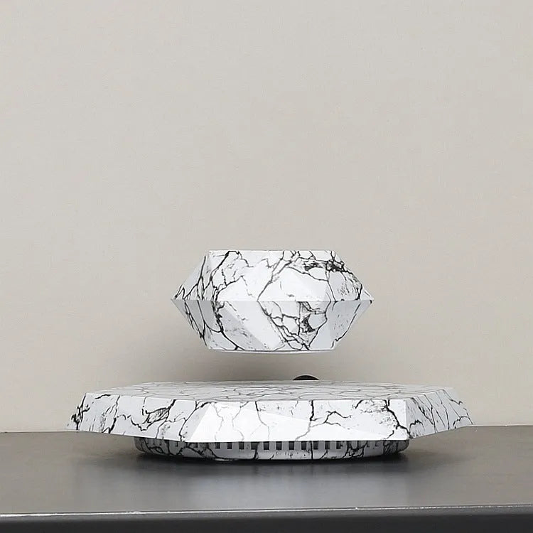 Marble-colour magnetic levitating plant pot floating and rotating a small succulent in mid-air.