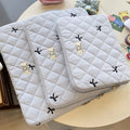 Nylon laptop storage bag with a rhombus-shaped embroidered bow on the front.