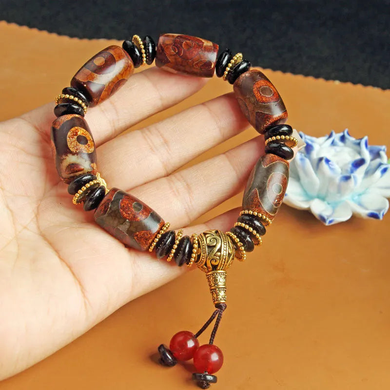 Distressed agate bracelet with traditional Tibetan dzi beads including three-eye and Nine Eyes designs.