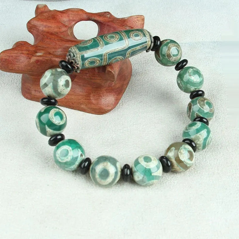 Distressed agate bracelet with traditional Tibetan dzi beads including three-eye and Nine Eyes designs.