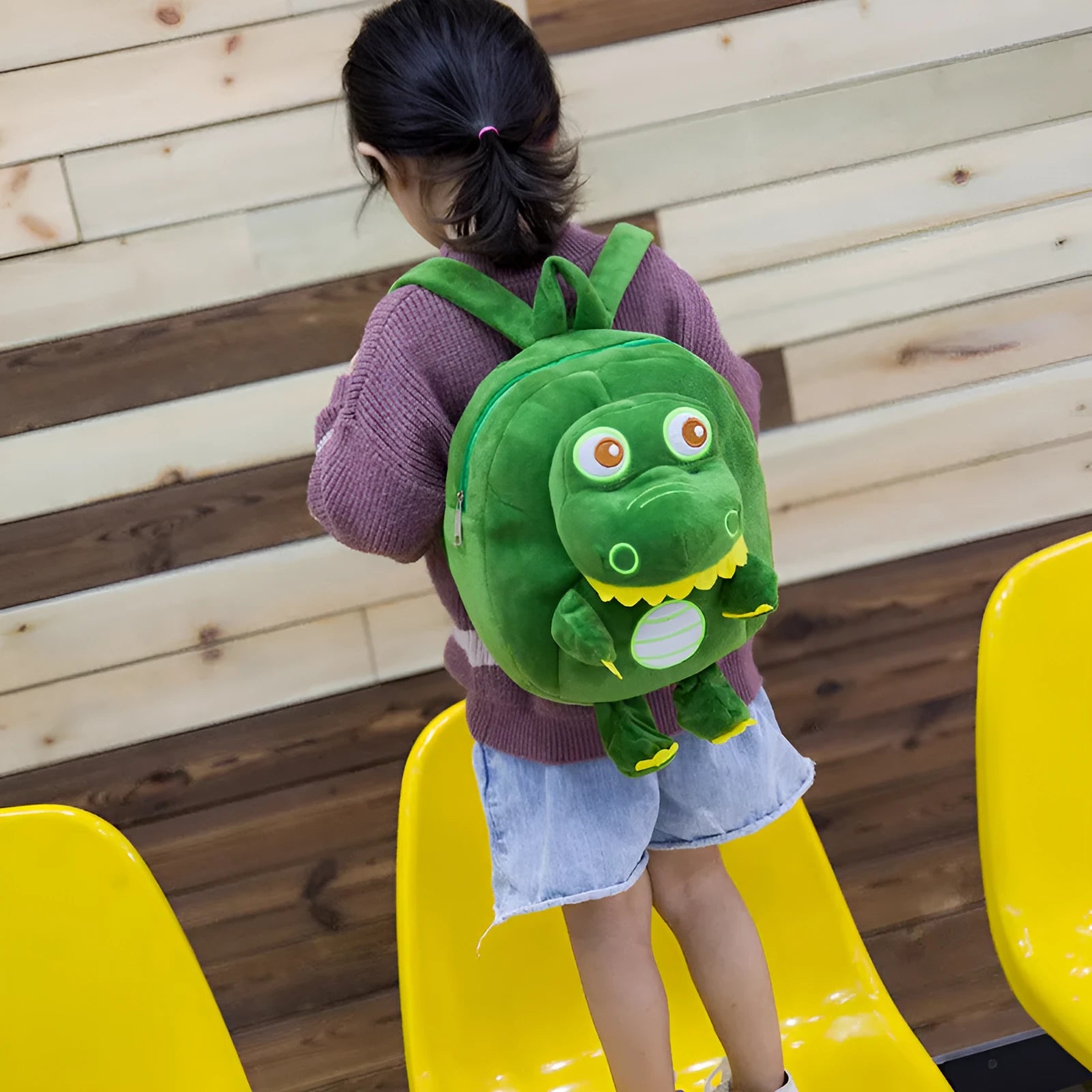 Blue dinosaur plush backpack for children with embroidery, soft handle, and polyester lining.