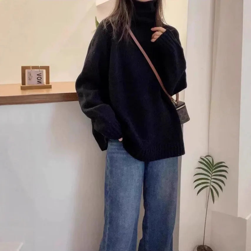 A woman's loose-fitting thick turtleneck sweater in a solid colour with a 3D textured pattern.