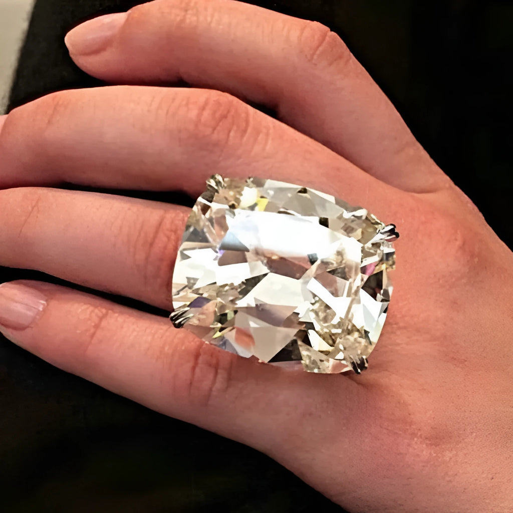 Simple inlaid white square diamond alloy ring for women in white gold colour on a grey background.