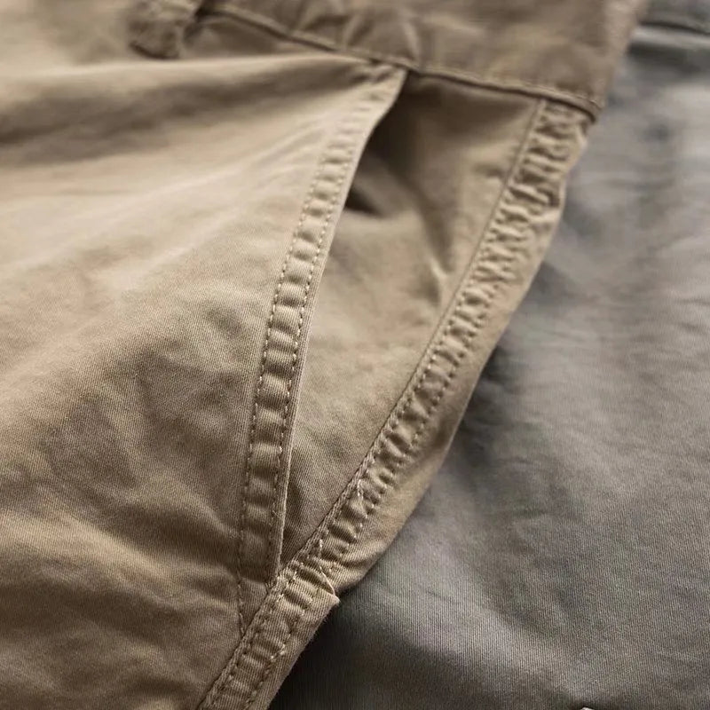 Men's cropped multi-pocket cotton work trousers in khaki, shown on a hanger.