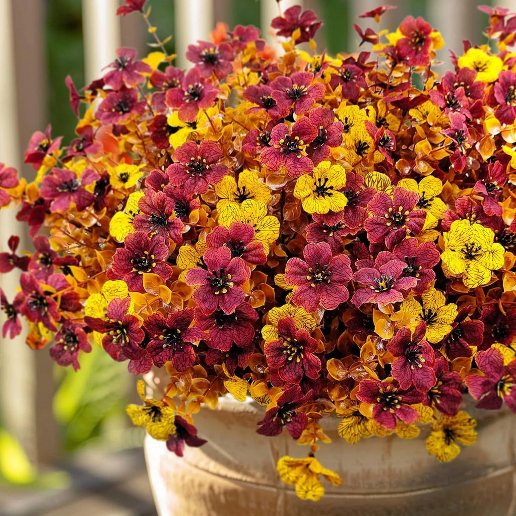 Artificial flower bouquet in autumn orange, red, and yellow colours for home and event decoration.