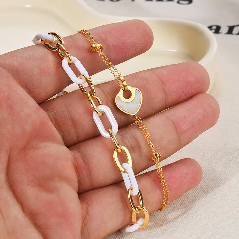 Women's stainless steel bracelet with a double-layer resin heart pendant.