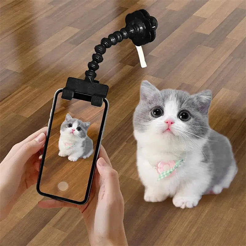 Black pet photography tool with rotating mount and phone clip for holding treats during animal photoshoots