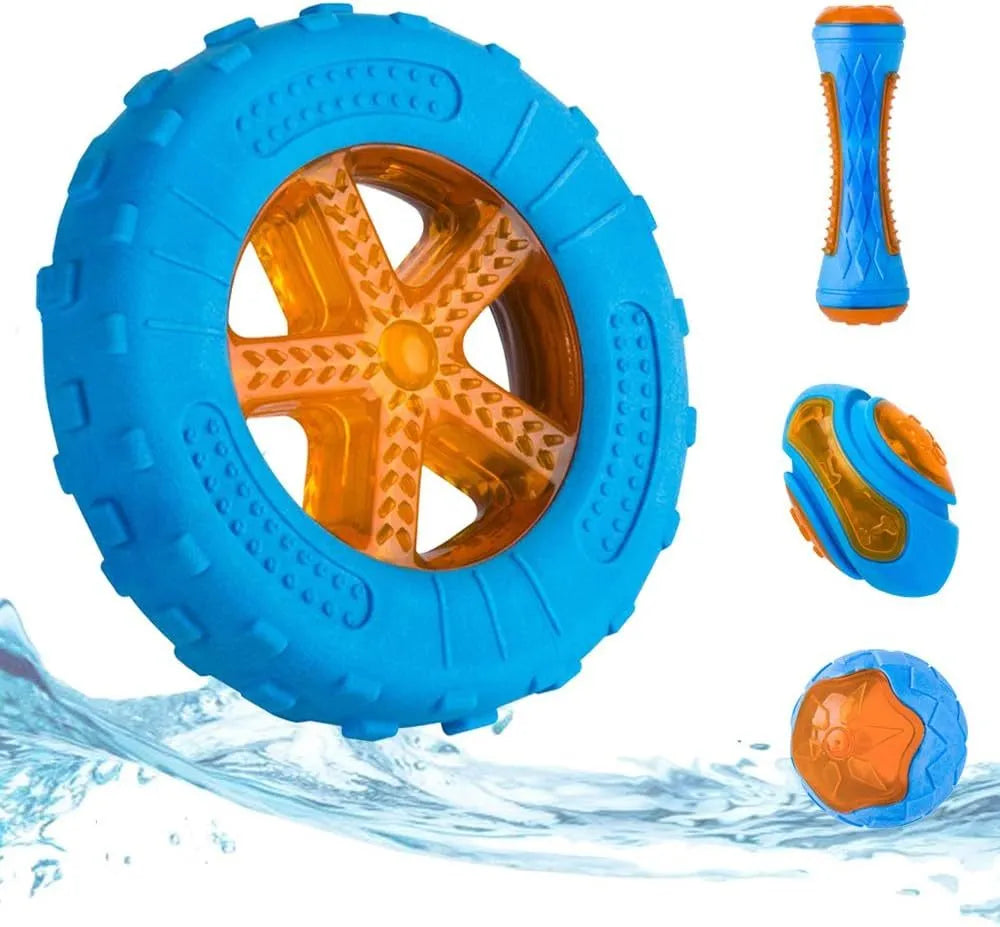 Set of three floating dog toys: a blue squeaky ball, an orange barbell, and red tyres on a beach.