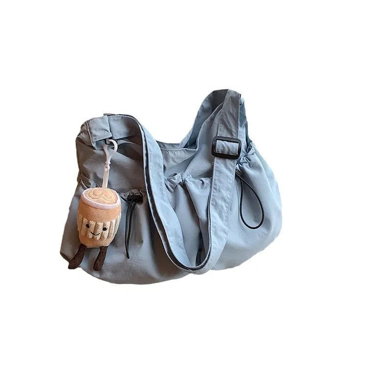 Green ultra-light pleated crossbody cloth bag showing split pocket and foldable design.