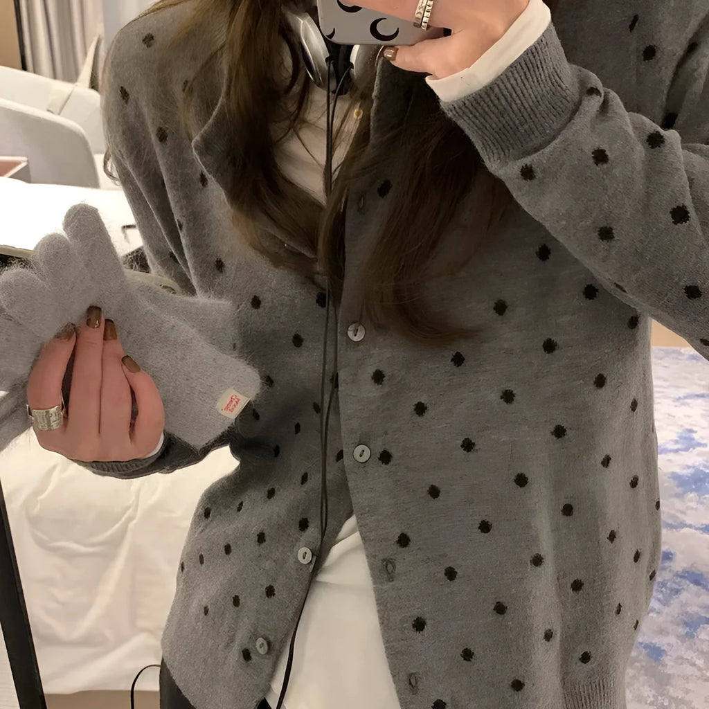 Grey women's knitted cardigan with a crocheted flower decoration on the front.