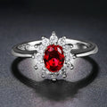 Copper flower-shaped ring with inlaid zirconia available in sapphire blue, green, and pomegranate red colours.
