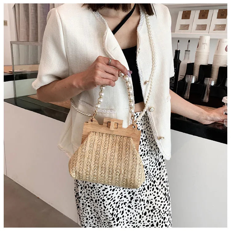 Women's woven straw beach bag with pearl chain shoulder strap in horizontal square shape