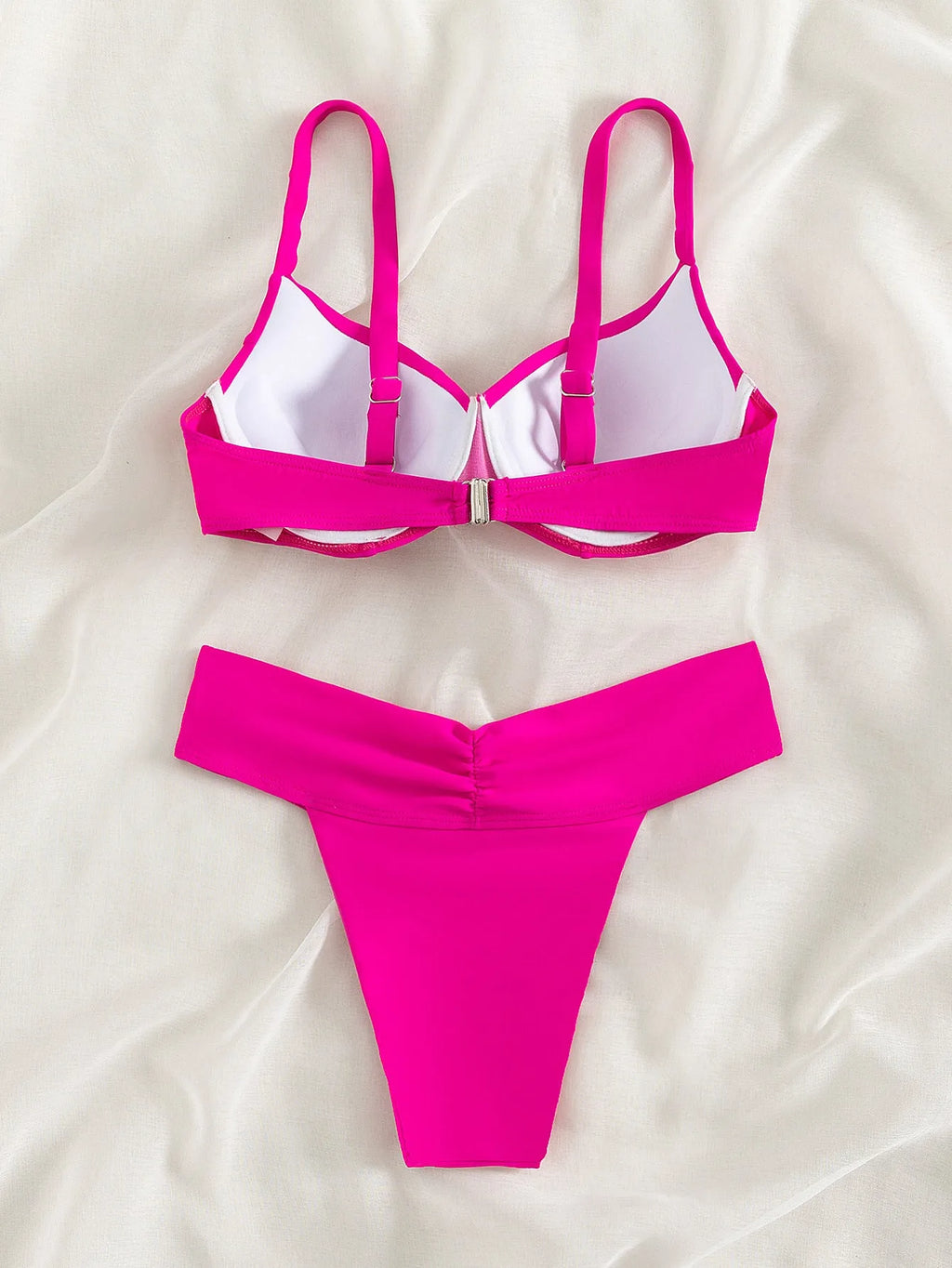 Solid colour briefs style bikini swimsuit in fluorescent pink on a mannequin.