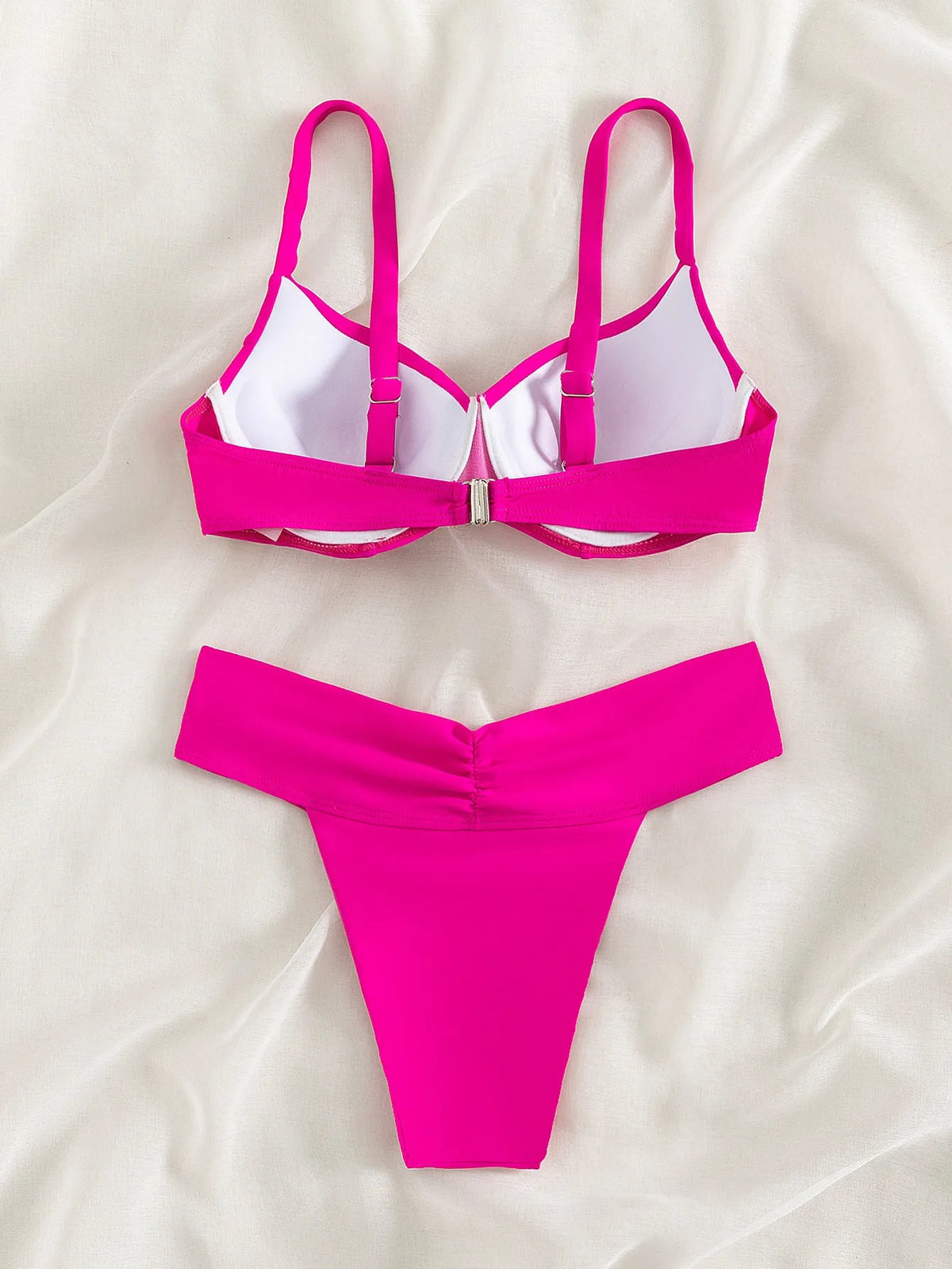 Solid colour briefs style bikini swimsuit in fluorescent pink on a mannequin.