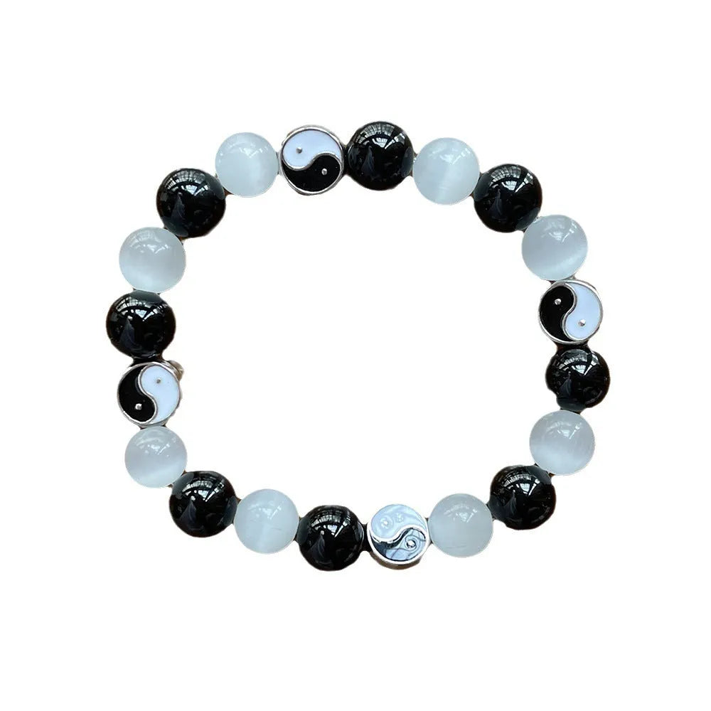 Close-up of a natural opal Tai Chi beaded bracelet with 10mm polished stones on a wrist.