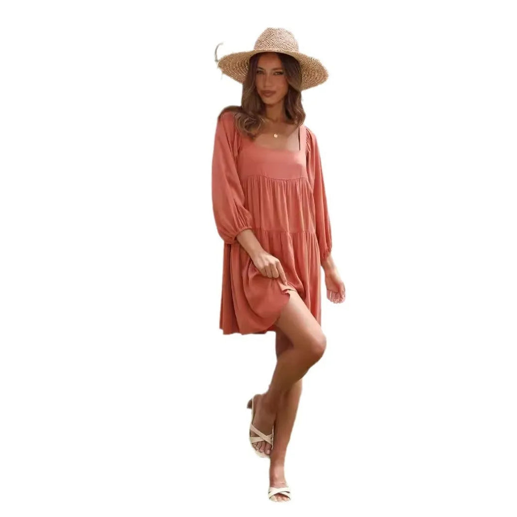 Orange backless children's dress with a square collar and puff sleeves on a mannequin.